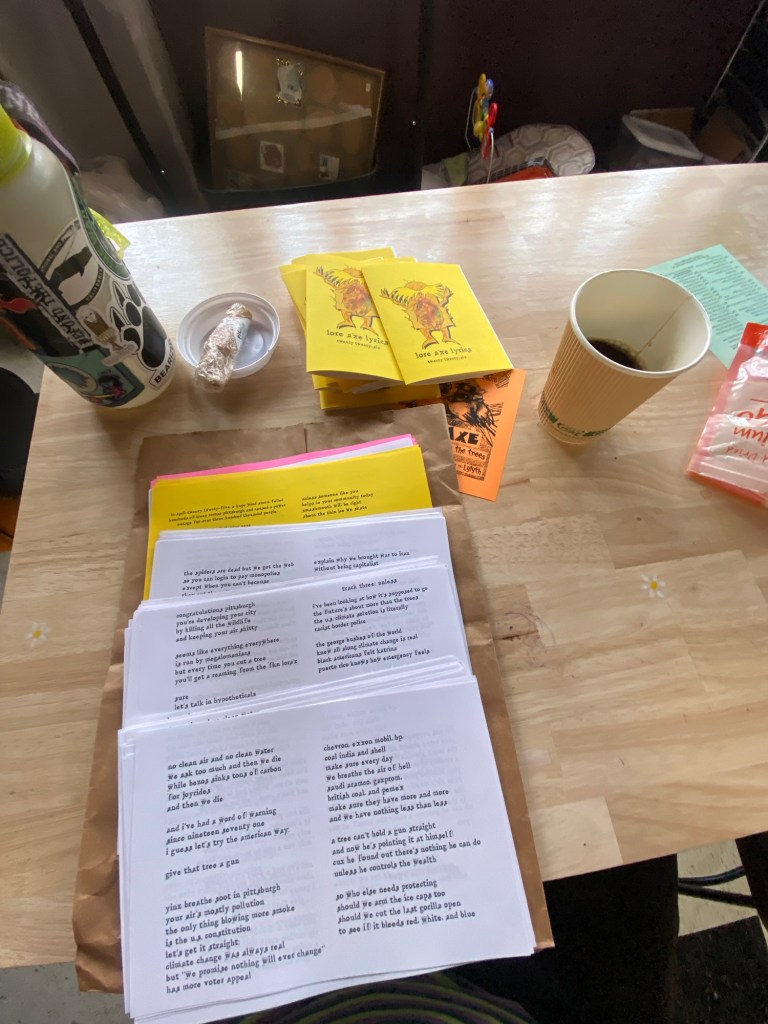 pages of the lore axe lyric book laid out next to a coffee