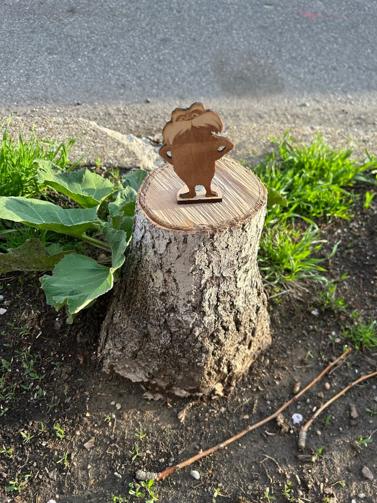 a lasercut Lorax nailed to a stump on Penn Ave